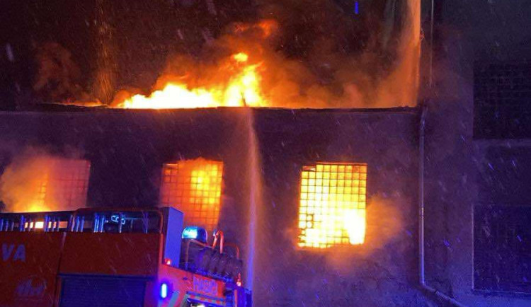 Hasiči likvidují rozsáhlý požár v areálu bývalých kasáren v Bruntále. Hoří uskladněné plastové piliny