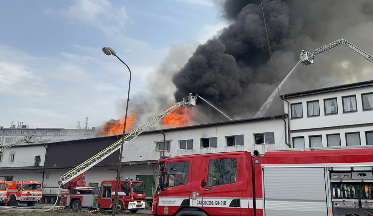 Na Žižkově hoří ubytovna, hasiči zachraňují lidi pomocí žebříků