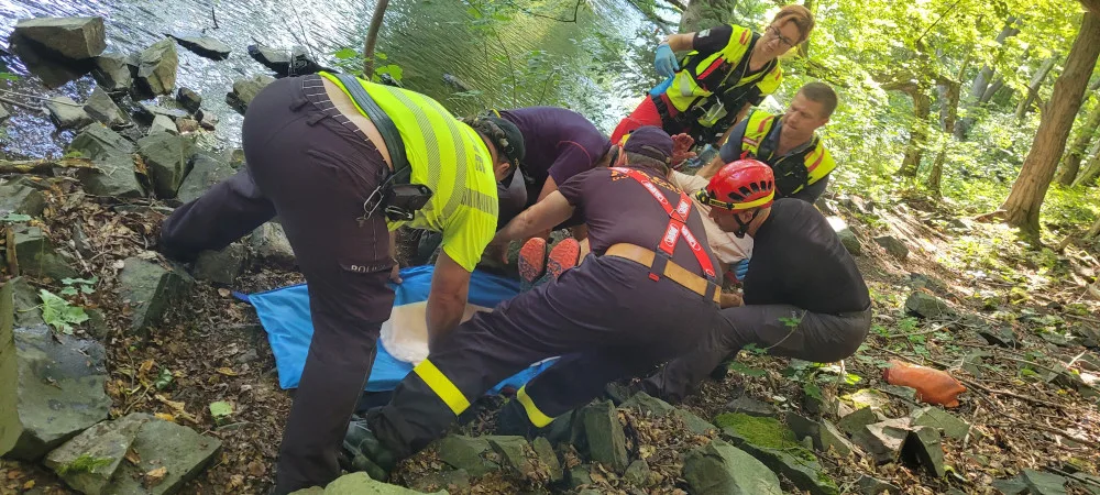Muž na Opavsku spadl ze dvacetimetrového srázu, k vrtulníku ho hasiči přepravili přes koryto řeky
