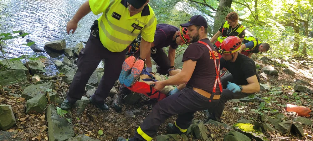 Muž na Opavsku spadl ze dvacetimetrového srázu, k vrtulníku ho hasiči přepravili přes koryto řeky