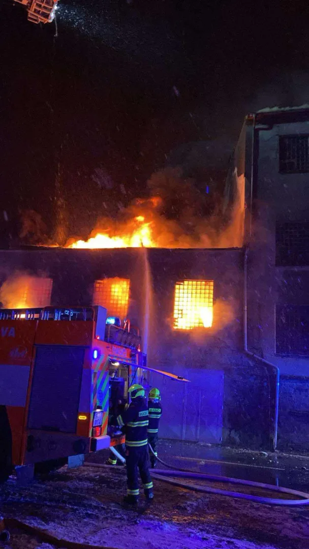 Hasiči likvidují rozsáhlý požár v areálu bývalých kasáren v Bruntále. Hoří uskladněné plastové piliny